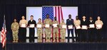 Eleven service members stand with their naturalization certificates.