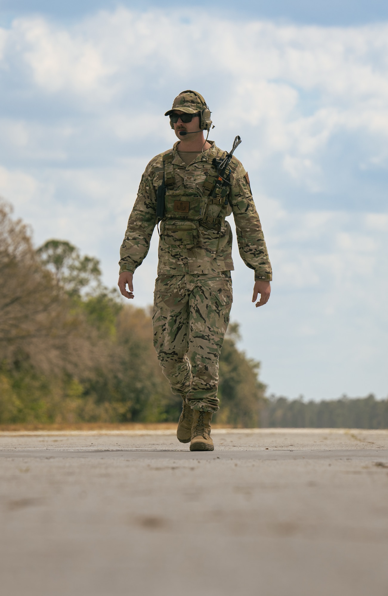 U.S. Air Force Tech. Sgt. Teddy Compston, 1st Special Operations Civil Engineer Squadron explosive ordnance disposal craftsman, walks down a flightline.