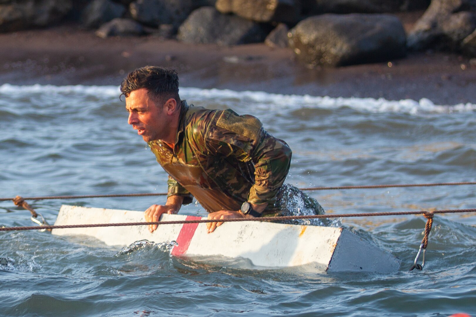 U.S. Army 1st Lt. Brendan Kalaf, the Headquarters Company, 1st Battalion, 69th Infantry Regiment, executive officer, overcomes a water obstacle during the French Desert Commando Course Jan. 30, 2023, in Djibouti.