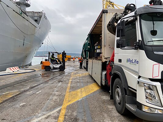 Barrels being unloaded from a ship.
