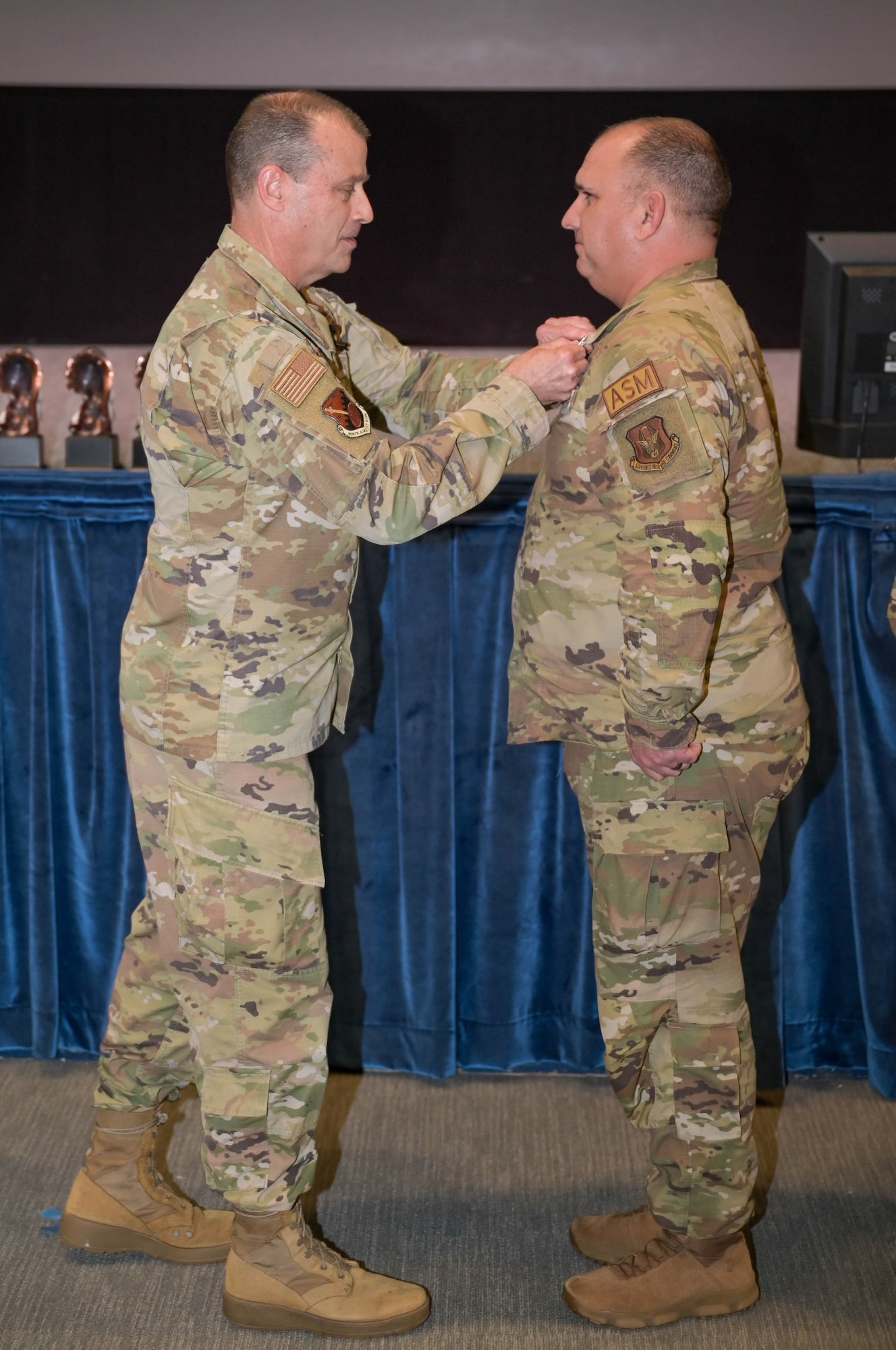 a man pins a medal on another man