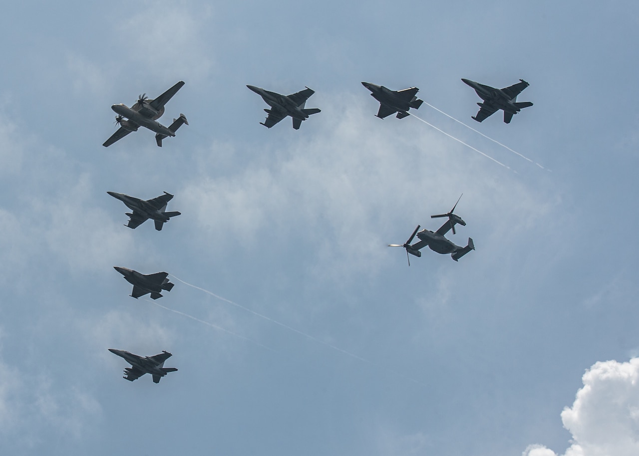 Aircraft flies in formation as seen from below.