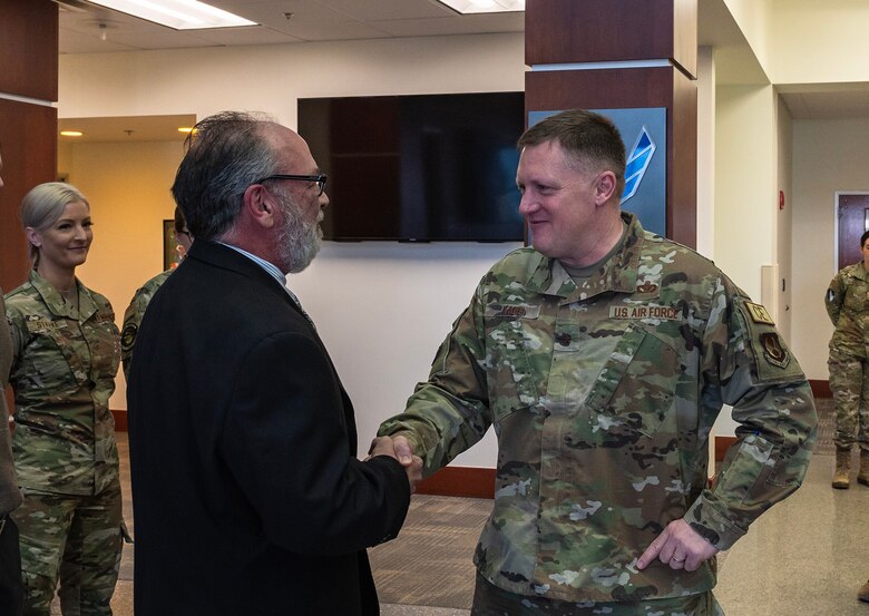 Two men shake hands.