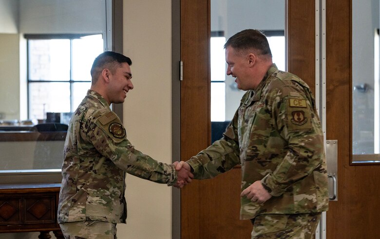 Two men shake hands.