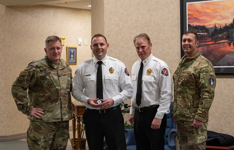 Four men pose for a photo