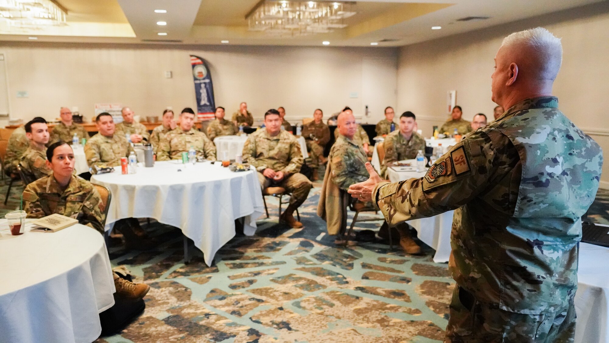 A speaker talks to a room full of people during a seminar.