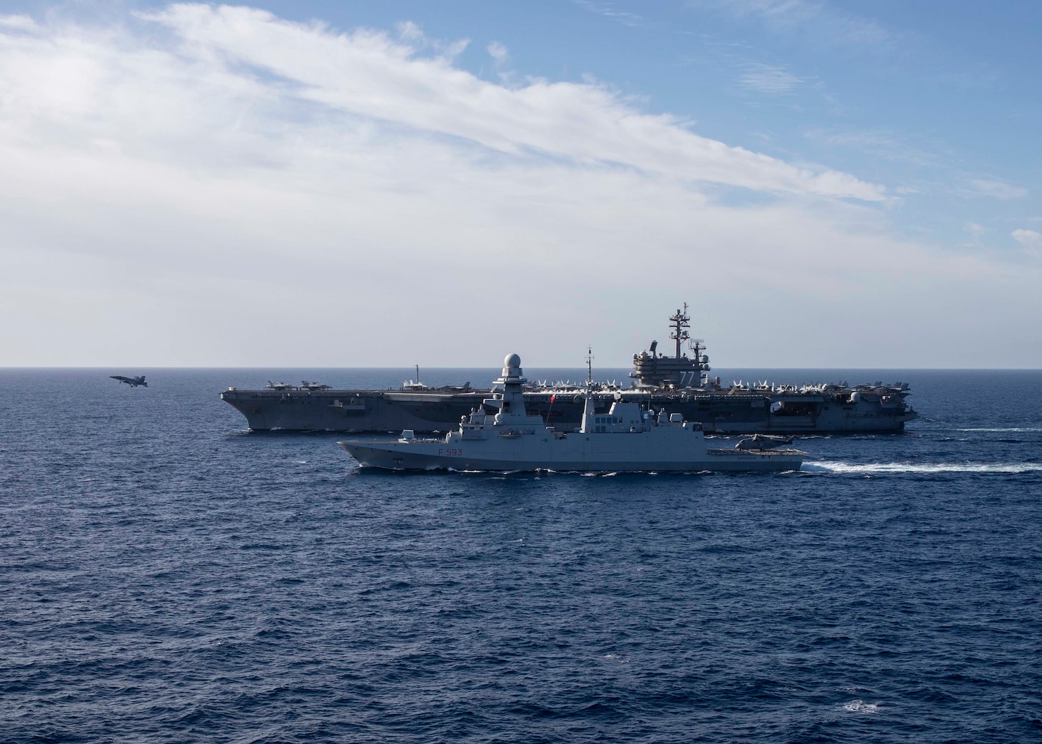 The Nimitz-class aircraft carrier USS George H.W. Bush (CVN 77) sails alongside the Italian Navy Carlo Bergamini-class frigate ITS Carabiniere (F 593) while an F/A-18 Super Hornet aircraft, assigned to Carrier Air Wing  (CVW) 7, takes off during combined operations in the Tyrrhenian Sea, Dec. 6, 2022. The George H.W. Bush Strike Group is on a scheduled deployment in the U.S. Naval Forces Europe area of operations, employed by U.S. Sixth Fleet to defend U.S., allied, and partner interests.