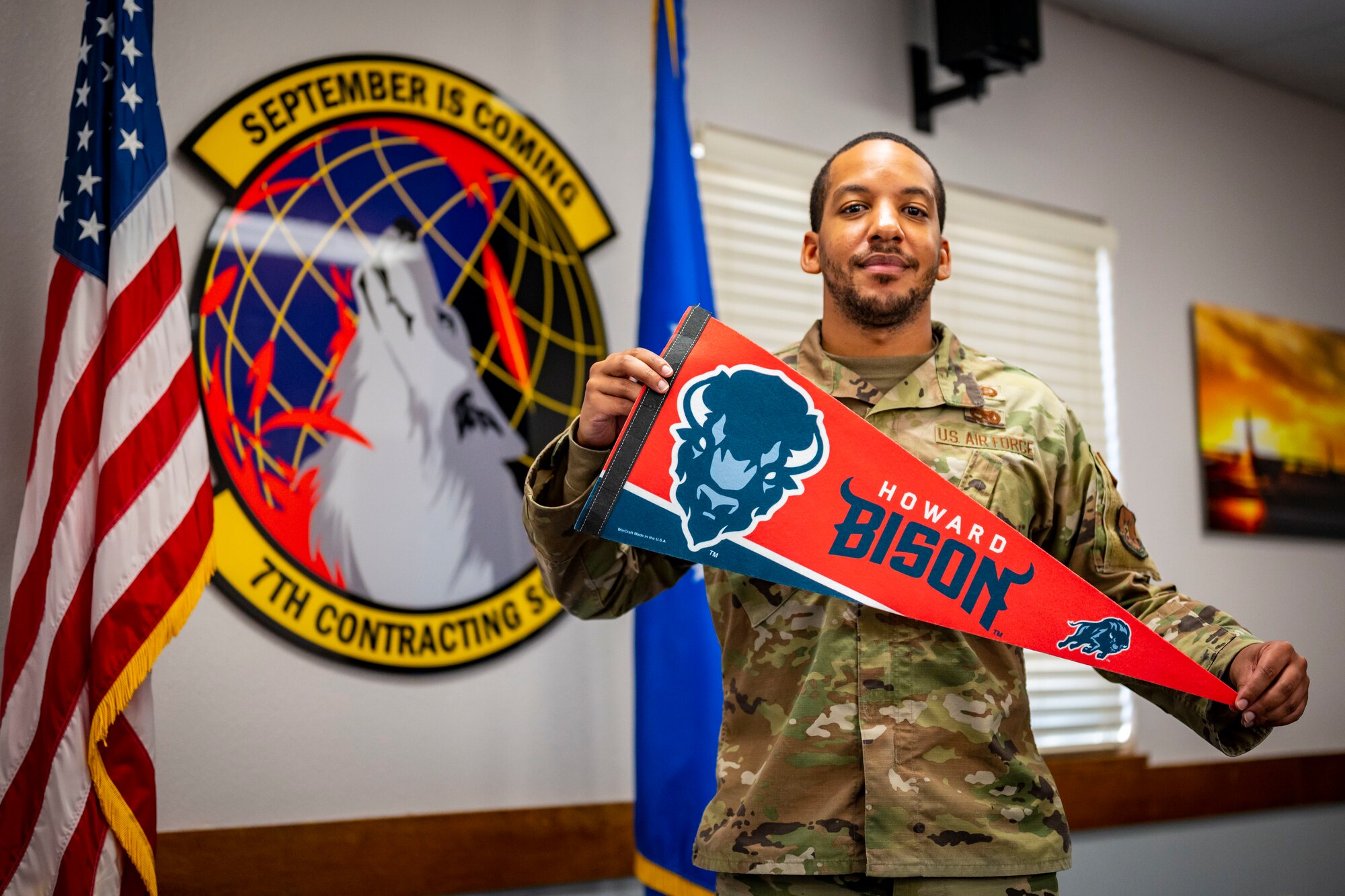 U.S. Air Force 2nd Lt. Dwight Williams, 7th Contracting Squadron Base Commodities Flight officer in charge, holds up a Howard University flag during Black History Month at Dyess Air Force Base, Texas, Feb. 22, 2023. Williams currently serves as the lead officer for the Dyess Diversity & Inclusion Committee and the Vice President of the Dyess African American Heritage Committee, hosting multiple events during his time at Dyess. He is a Big Brother in the Big Brothers Big Sisters program and spends his spare time as a disk jockey attending multiple events throughout the community, offering his musical knowledge and event coordination skills. (U.S. Air Force photo by Senior Airman Leon Redfern)