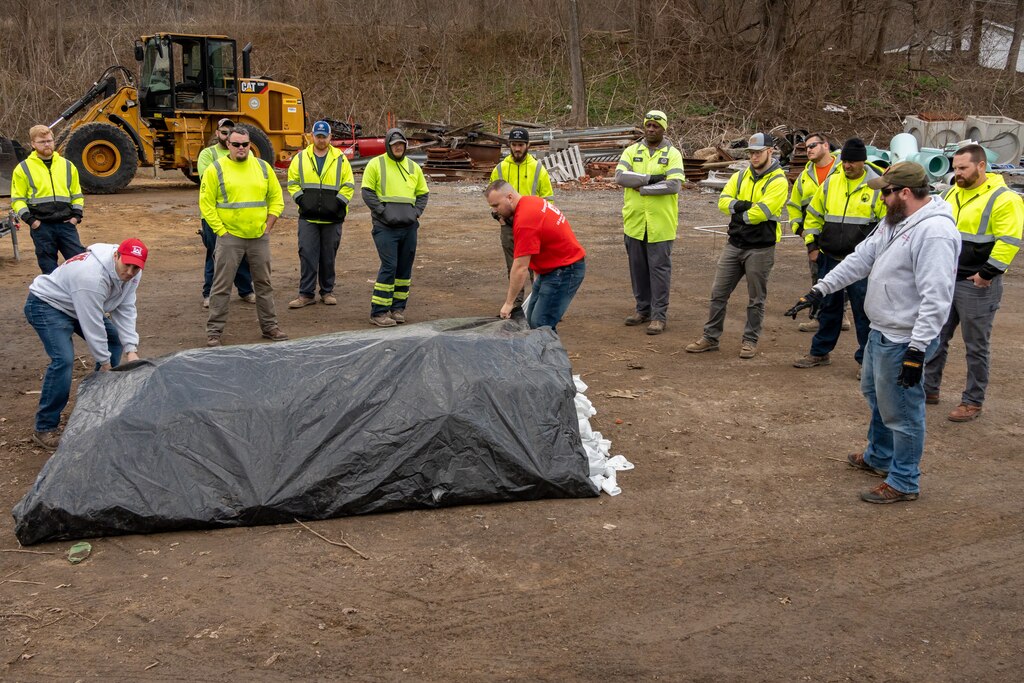 U.S. Army Corps of Engineers Louisville District Emergency Management Chief George Minges and Emergency Management Planner Jeff Brooks wrap a levee with plastic during flood fight training, Feb. 9, 2023 in Frankfort, Kentucky.