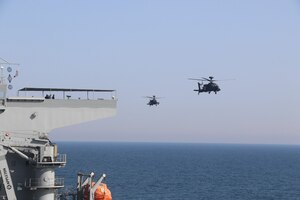 ARABIAN GULF (Feb. 22, 2023) Two United Arab Emirates Armed Forces AH-64D Long Bow Apaches conduct deck landing qualifications aboard expeditionary sea base USS Lewis B. Puller (ESB 3) in the Arabian Gulf, Feb. 22, 2023. Puller is deployed to the U.S. 5th Fleet area of operations to help ensure maritime security and stability in the Middle East region.