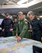 Vice Adm. Thomas Ishee reviews a chart aboard the Italian navy aircraft carrier ITS Cavour (CVH 550) in the Adriatic Sea.