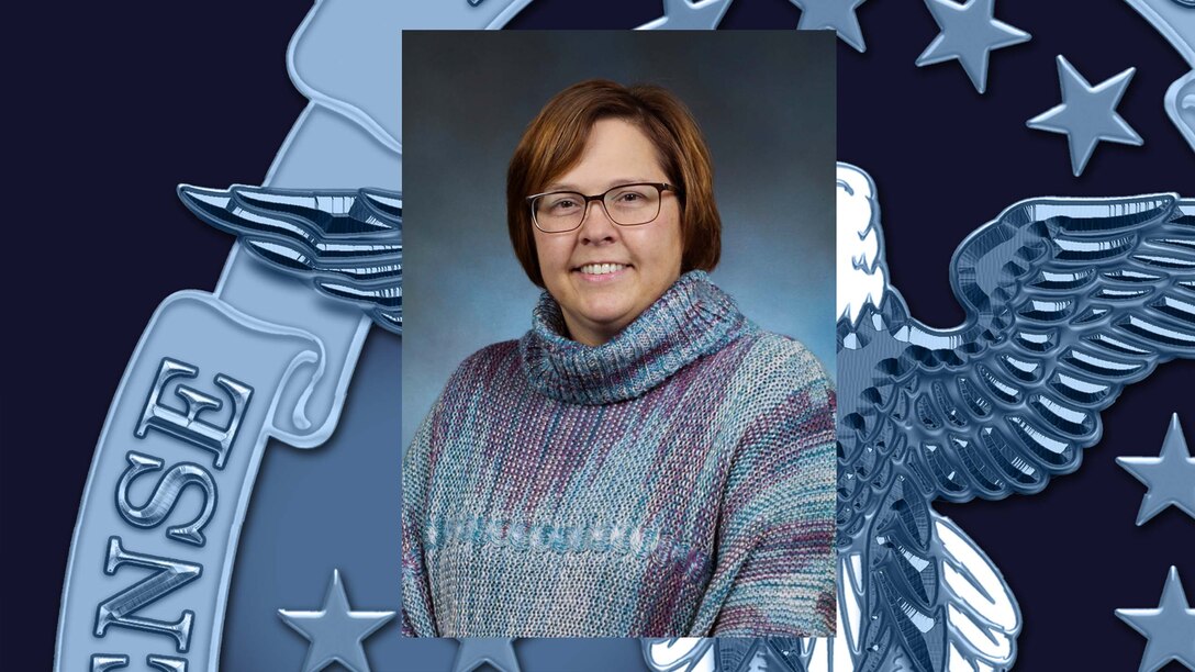 Professional portrait of female with blue background.