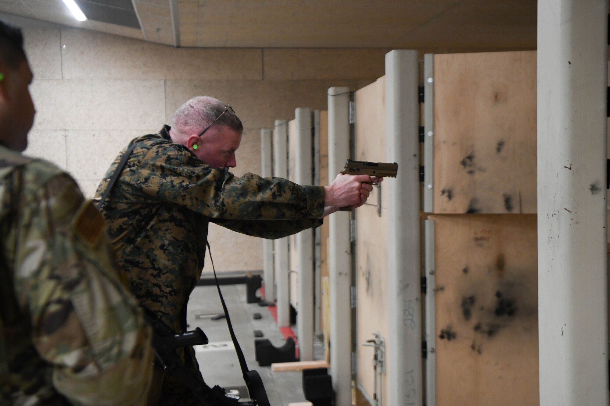 Man aims weapon at target