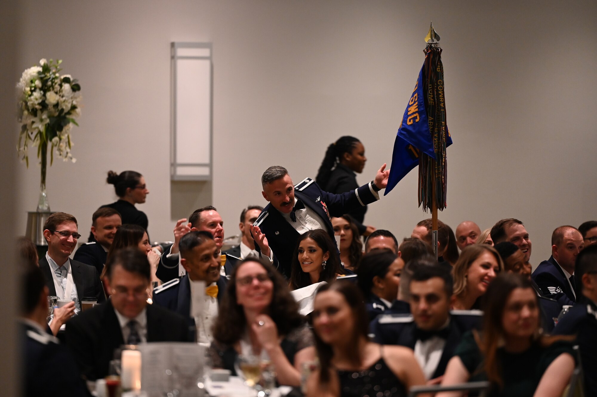 U.S. Air Force Lt. Col. Kyle Schlewinsky, 68th Electronic Warfare commander, standing, responds to words from the wing commander during the 350th Spectrum Warfare Wing’s annual awards ceremony at Eglin Air Force Base, Fla., Feb. 24, 2023. 29 individuals, three teams and two units were nominated for annual awards, but all received a medallion as recognition for their contributions to the wing’s mission. (U.S. Air Force photo by 1st Lt Benjamin Aronson)