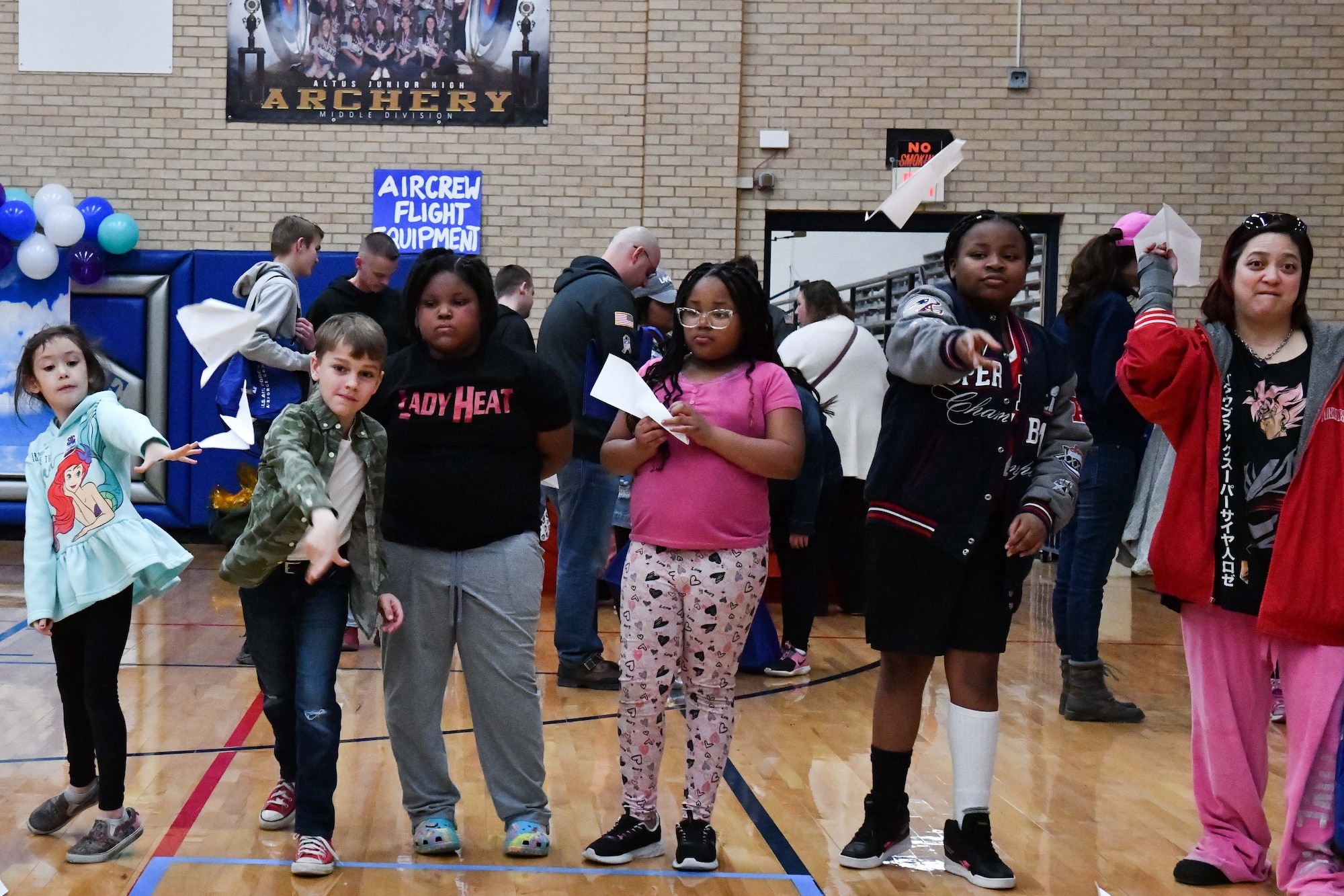 Children participate in a paper plane contest during an aviation fair at Altus Junior High School, Altus, Oklahoma, Feb. 25, 2023. The event provided an opportunity for children to learn about aviation and aviation-based career fields. (U.S. Air Force photo by Airman 1st Class Miyah Gray)