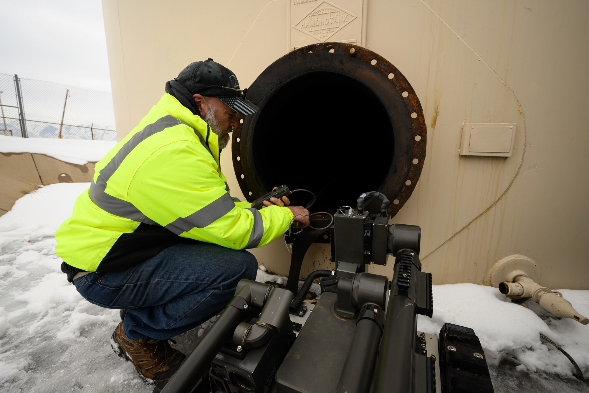 A civilian worker inserts a probe into a fuel tank
