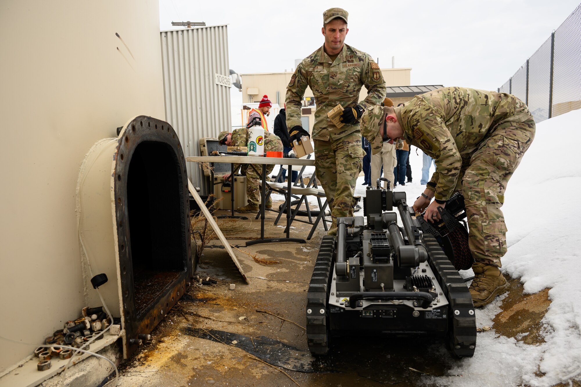 two airmen using a robot