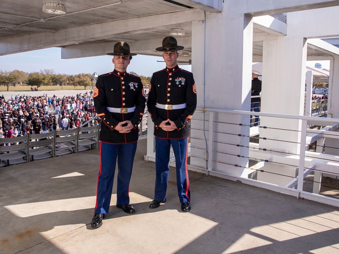 Staff Sgt. Christopher Davis and Staff Sgt. Mark Gulotta, with the Recruit Training Regiment, pose for a photo on the Peatross Parade aboard Marine Corps Recruit Depot Parris Island, S.C., Feb 25, 2022. Davis spent weeks training Gulotta to take over the position of "the voice". (U.S. Marine Corps photo by Lance Cpl. Michelle Brudnicki)