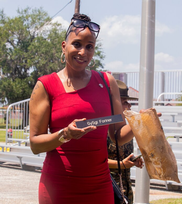 Sgt. Maj. Robin C. Fortner (Ret.) holds up her Drill Instructor placard from within the time capsule on Marine Corps Recruit Depot Parris Island S.C., May 5, 2022. Fortner buried multiple items as the Battalion Sergeant Major in 2012 at the time of the celebration. (U.S. Marine Corps photo by Lance Cpl. Michelle Brudnicki)