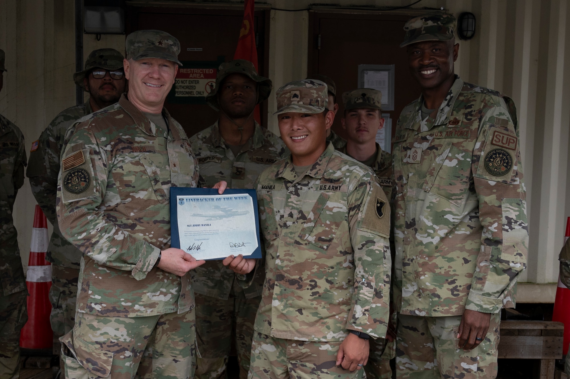 U.S. Army Sgt. Jimmy Manila, the Battery E, 3rd Air Defense Artillery noncommissioned officer in charge assigned to the E-3 Terminal High Altitude Area Defense, receives the Linebacker of the Week Award from U.S. Air Force Brig. Gen. Paul Birch, commander of the 36th Wing, and U.S. Air Force Chief Master Sgt. Nicholas Taylor, the command chief of the 36th Wing, at Andersen Air Force Base, Guam, Feb. 22, 2023. The Team Andersen Linebacker of the Week recognizes outstanding enlisted, officer, civilian and total force personnel who have had an impact on achieving Team Andersen’s mission, vision and priorities. (U.S. Air Force photo by Airman 1st Emily Saxton)