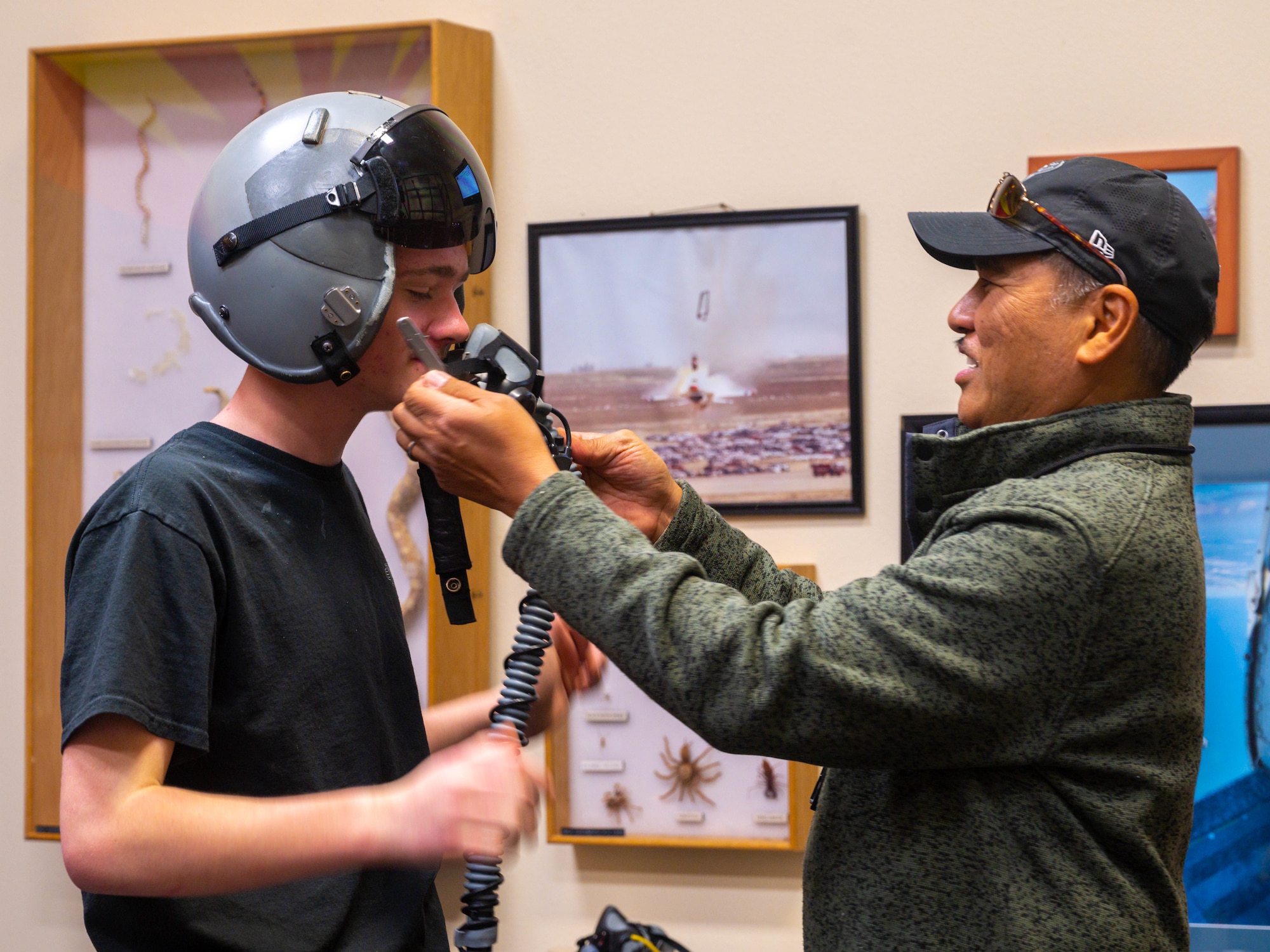 Akoni Mirafuentes, 56th Operations Support Squadron aircrew flight equipment instructor, attaches a face mask to a Prescott High School Air Force JROTC student, Feb. 21, 2023, at Luke Air Force Base, Arizona.