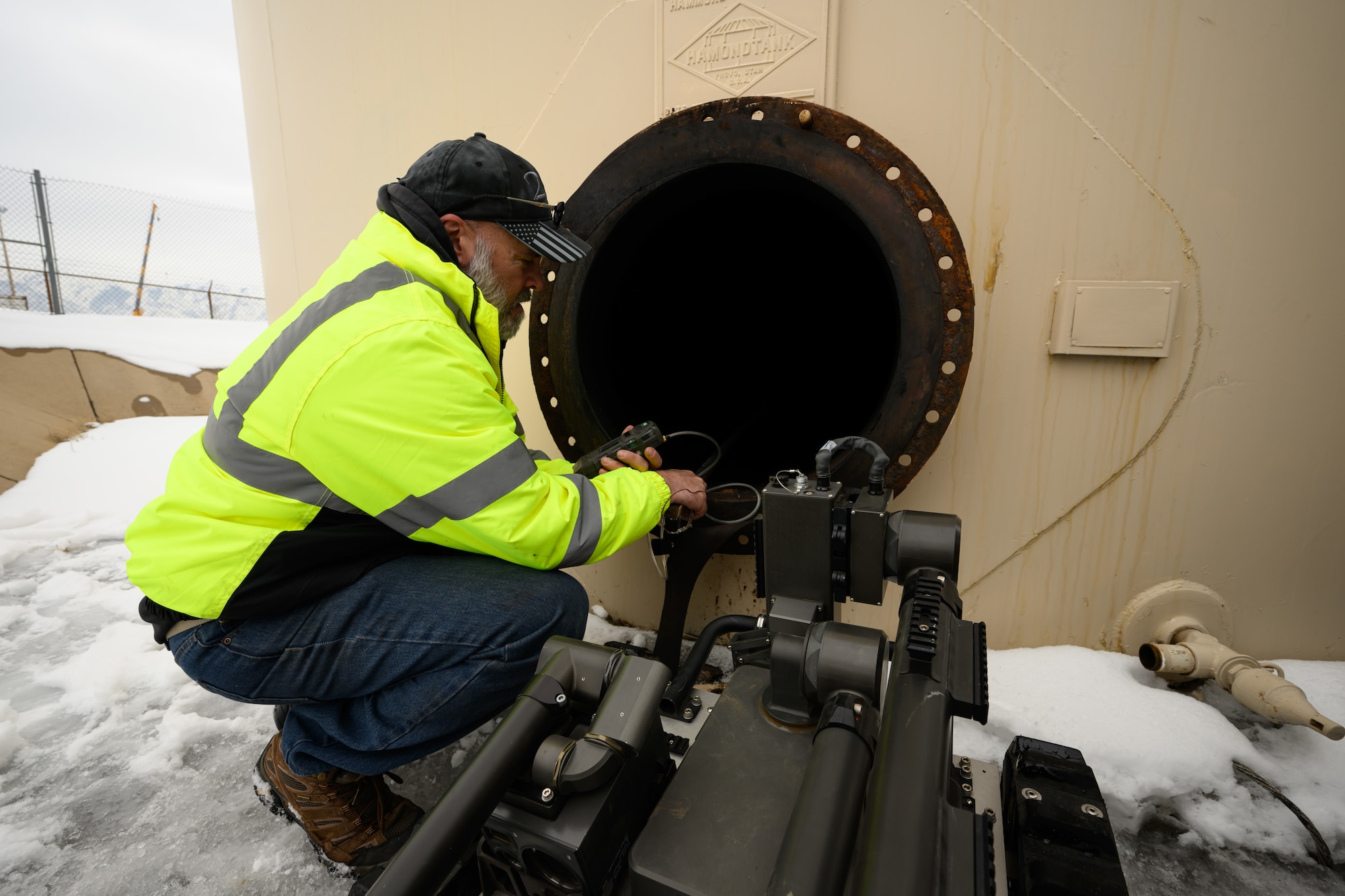 A civilian worker inserts a probe into a fuel tank