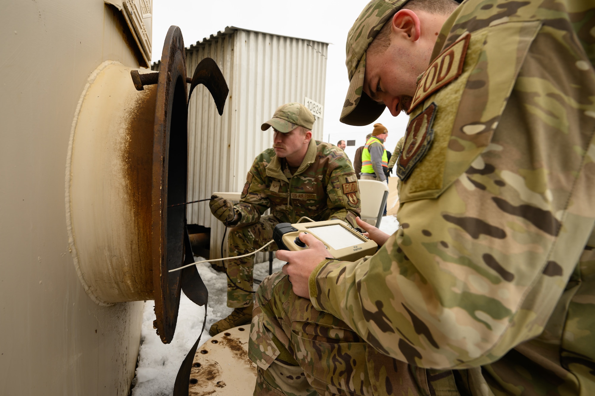 An airman looks at a video monitor that is sending images from inside a fuel tank