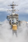(Nov. 23, 2022) Aviation Boatswain’s Mate (Handling) 3rd Class Roberto Cerdas assigned to the Nimitz-class aircraft carrier USS George H.W. Bush (CVN 77), directs a French Rafale fighter jet onto the catapult during multi-carrier operations between the George H.W. Bush Carrier Strike Group (CSG), Charles de Gaulle CSG, and the Italian Cavour CSG Nov. 23, 2022. The George H.W. Bush CSG is on a scheduled deployment in the U.S. Naval Forces Europe area of operations, employed by U.S. Sixth Fleet to defend U.S., allied, and partner interests.