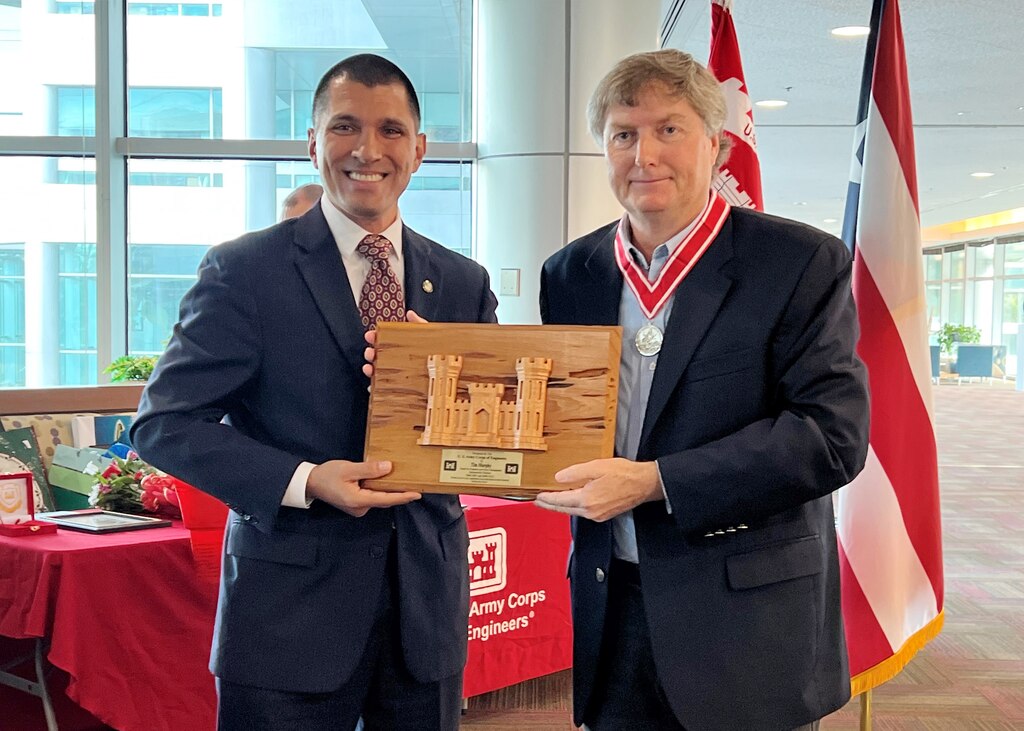 Howard Gonzales, the incoming deputy district engineer for Programs and Project Management, presents Tim Murphy, the outgoing deputy district engineer, with the Jacksonville District Pecky Cypress Award during a retirement ceremony Dec. 15, 2022 in Jacksonville, Fla. (USACE Photo by Mark Rankin)