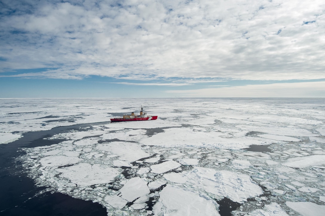 A Coast Guard cutter navigates through icy water.