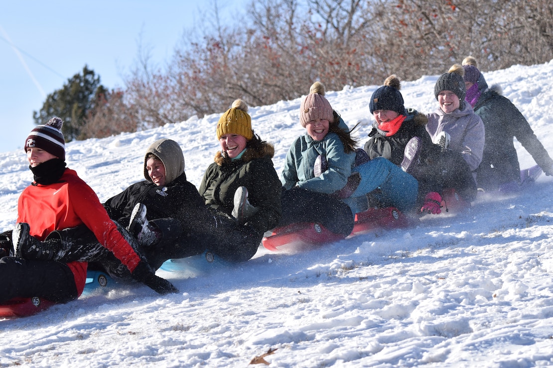 Group of People Sledding by Visitor Center