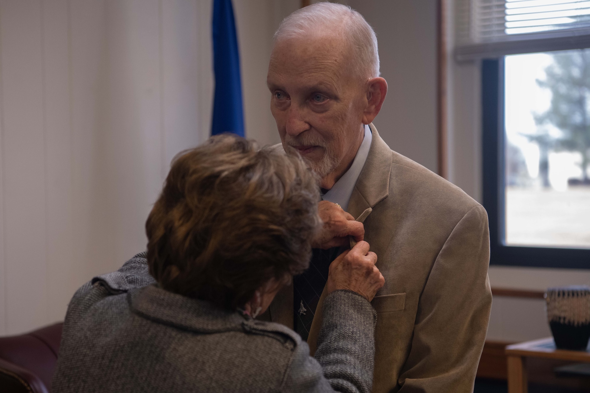 Gregory Baker receives a pin from his wife during a retirement ceremony Dec. 30, 2022. In 1974, Baker was the first civilian selected to attend Squadron Officer School in residence. He also had learning opportunities at Air Command Staff College and the Academic Instructors Course.