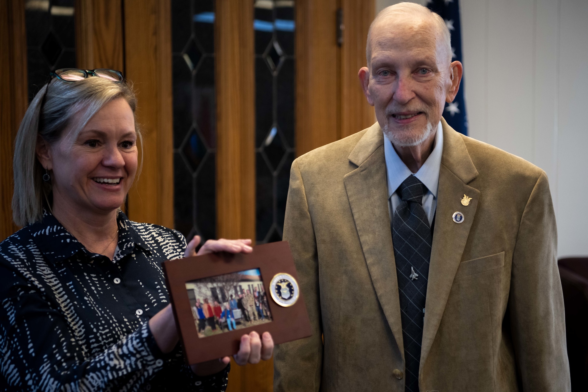 Gregory Baker and Ginny Zipen, Chief, International Engagements Branch show a photo to the audience during a retirement ceremony at Maxwell Air Force Base, Dec. 30, 2022. Baker’s career began on June 9, 1969, as an assistant professor of language at what is now known as the International Officer School.