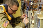 Spc. Kaden Scherger, with the 1137th Signal Company TIN-E (Tactical Installation and Networking-Enhanced), tests network connections during an infrastructure improvement project April 26, 2022, at Rickenbacker Air National Guard Base in Columbus, Ohio. The 1137th's primary mission to install and maintain computer network infrastructure.
