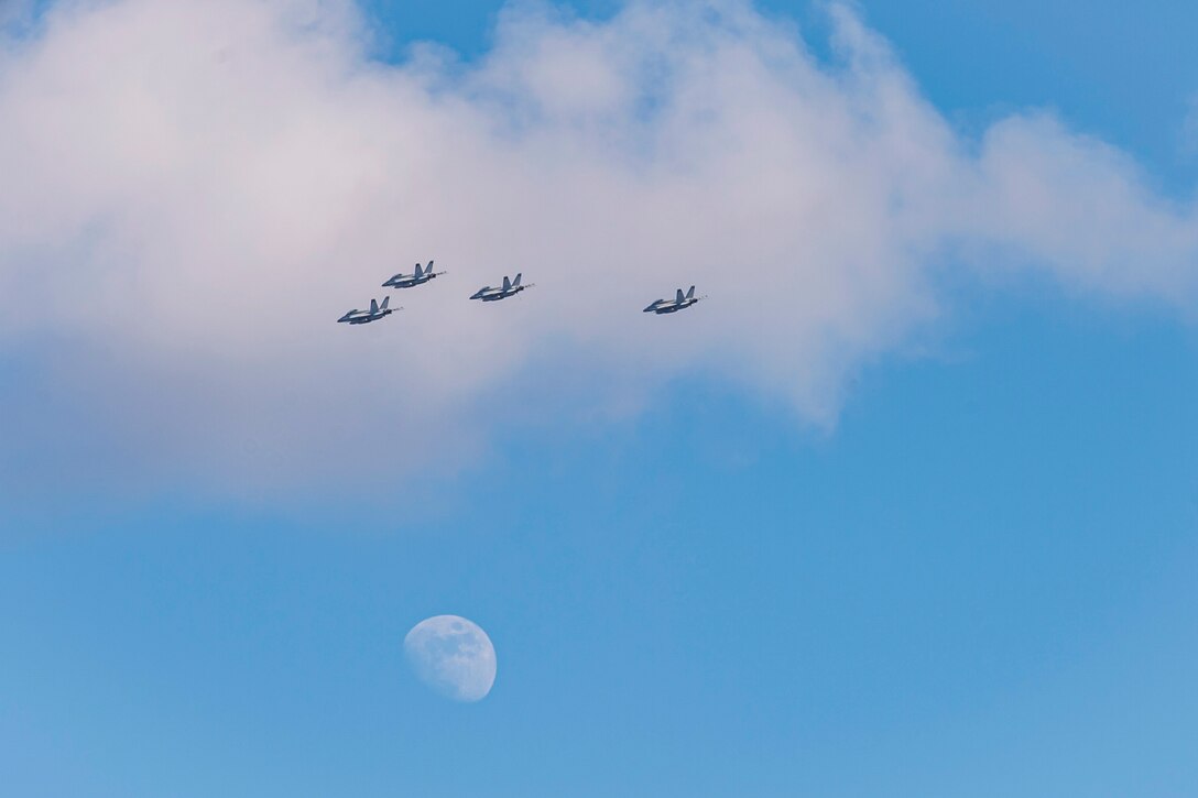 Four aircraft fly in formation through a cloud.