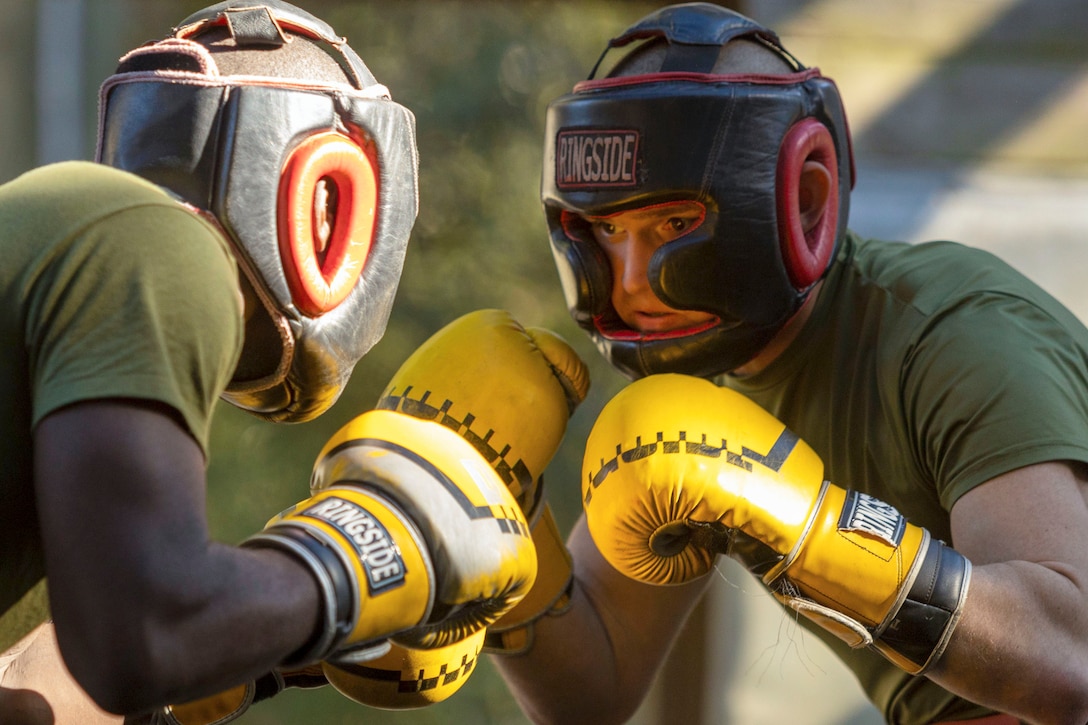 Two Marine Corps recruits participate in a boxing match.