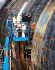 Shop 75 employees working in Dry Dock # 3 remove "SHT" Special Hull Treatment from the hull of the EX-USS Augusta SSN-710 (U.S. Navy photo by Wendy Hallmark)