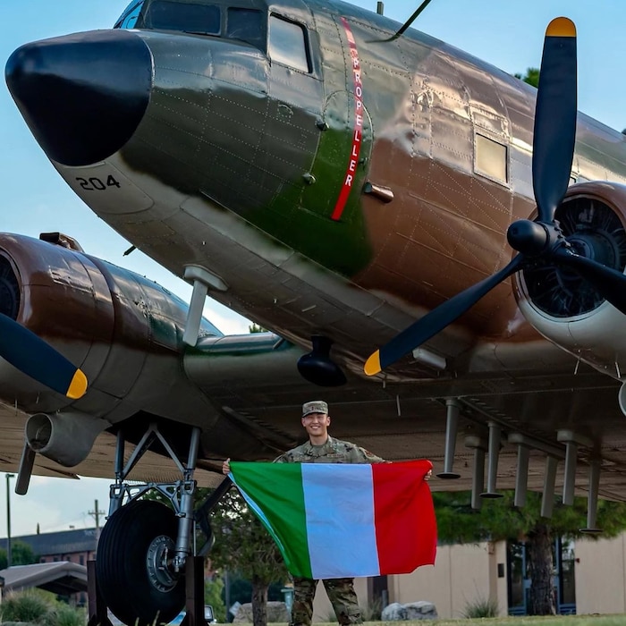 Airman standing in front of plane with French flag