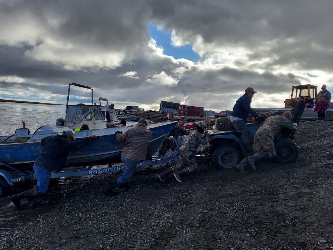 Service members assigned to Joint Task Force – Bethel work with the local community of Chevak, Alaska in towing a boat from the river as part of Operation Merbok Response, Sept. 22, 2022. More than 130 members of the Alaska Organized Militia, which includes members of the Alaska National Guard, Alaska State Defense Force and Alaska Naval Militia, were activated following a disaster declaration issued Sept. 17 after the remnants of Typhoon Merbok caused dramatic flooding across more than 1,000 miles of Alaskan coastline. (Alaska National Guard photo by Senior Airman Emily Batchelor)