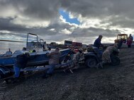 Service members assigned to Joint Task Force – Bethel work with the local community of Chevak, Alaska in towing a boat from the river as part of Operation Merbok Response, Sept. 22, 2022. More than 130 members of the Alaska Organized Militia, which includes members of the Alaska National Guard, Alaska State Defense Force and Alaska Naval Militia, were activated following a disaster declaration issued Sept. 17 after the remnants of Typhoon Merbok caused dramatic flooding across more than 1,000 miles of Alaskan coastline. (Alaska National Guard photo by Senior Airman Emily Batchelor)