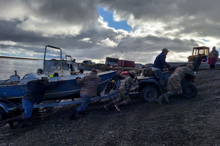 Service members assigned to Joint Task Force – Bethel work with the local community of Chevak, Alaska in towing a boat from the river as part of Operation Merbok Response, Sept. 22, 2022. More than 130 members of the Alaska Organized Militia, which includes members of the Alaska National Guard, Alaska State Defense Force and Alaska Naval Militia, were activated following a disaster declaration issued Sept. 17 after the remnants of Typhoon Merbok caused dramatic flooding across more than 1,000 miles of Alaskan coastline. (Alaska National Guard photo by Senior Airman Emily Batchelor)