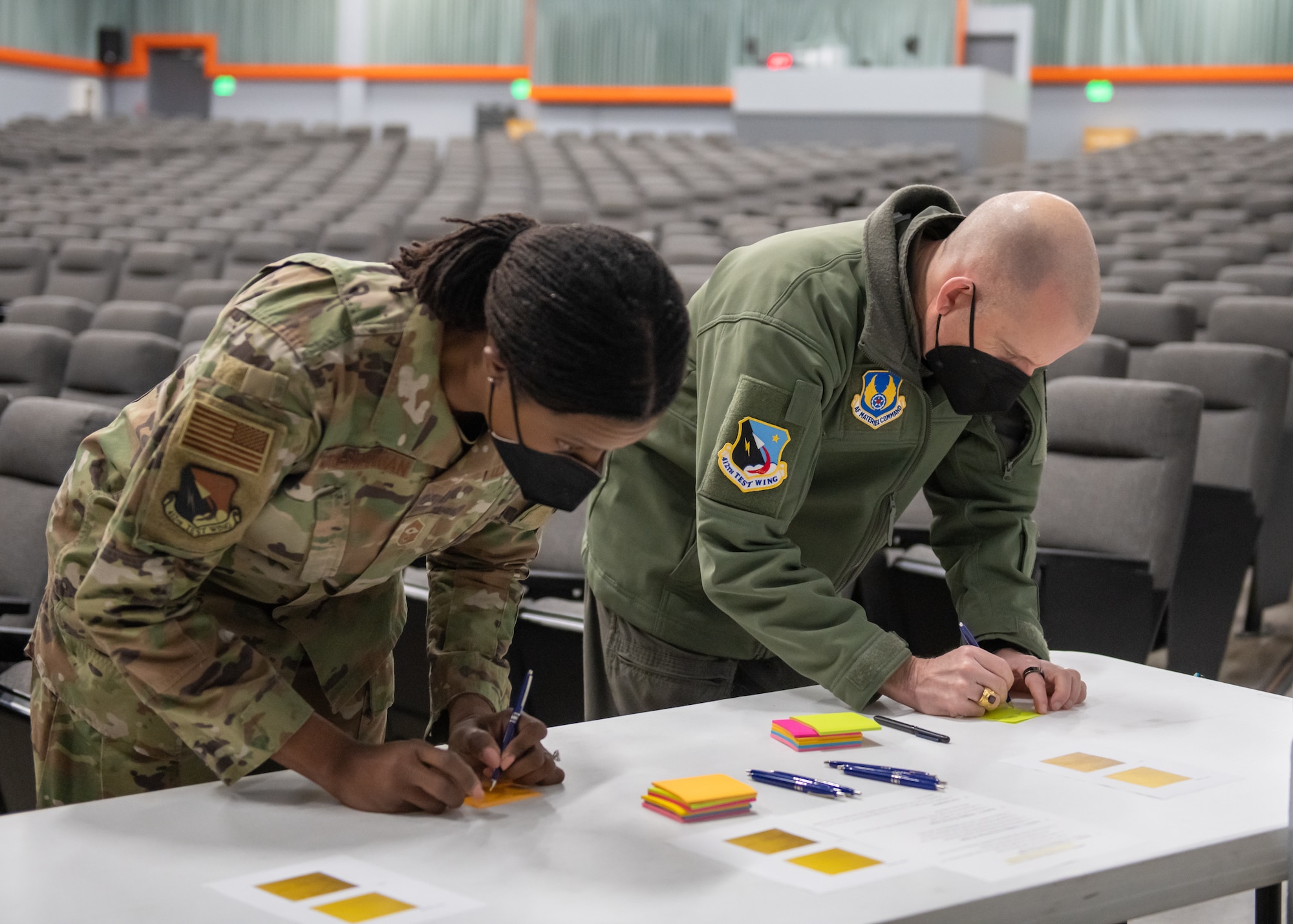 412th Test Wing Commander, Brig. Gen. Matthew Higer and 412th Test Wing Command Chief Master Sergeant Denisha Ward-Swanigan submit a COVID-19 self-test kit at the Single Point Screening Facility Test Facility (SPSTF) at the Base Theater on Edwards Air Force Base, California. The SPSTF will hold COVID-19 proactive screening tests Jan. 4-12, from 7:30 a.m. to 4 p.m. (Air Force photo by Giancarlo Casem)