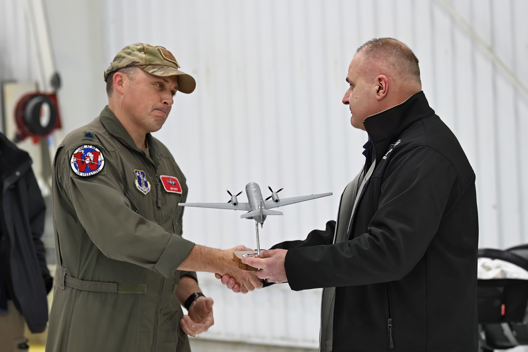 U.S. Army Col. Paul Felician, director of the Wisconsin National Guard's Counter Drug Program, right, recognizes Lt. Col. Benjamin West, Wisconsin RC-26 program manager, following the final flight of the state's RC-26B reconnaissance aircraft Dec. 28, 2022.