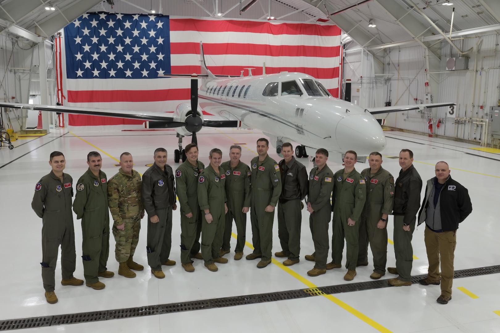 115th Fighter Wing pilots and military information support operators for the Wisconsin Air National Guard's RC-26B reconnaissance aircraft gather with Wisconsin National Guard leadership following the aircraft's final flight Dec. 28, 2022.