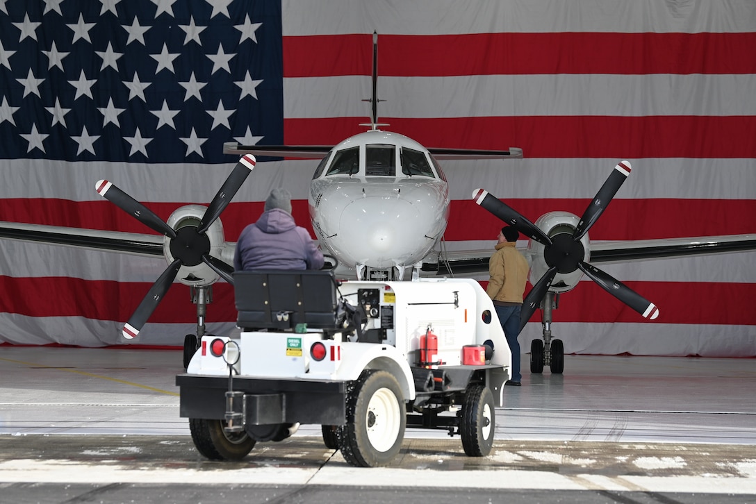 Maintenance specialists for the Wisconsin Air National Guard's RC-26B reconnaissance aircraft back it into an aircraft hangar at Dane County Regional Airport following it's final flight Dec. 28, 2022.