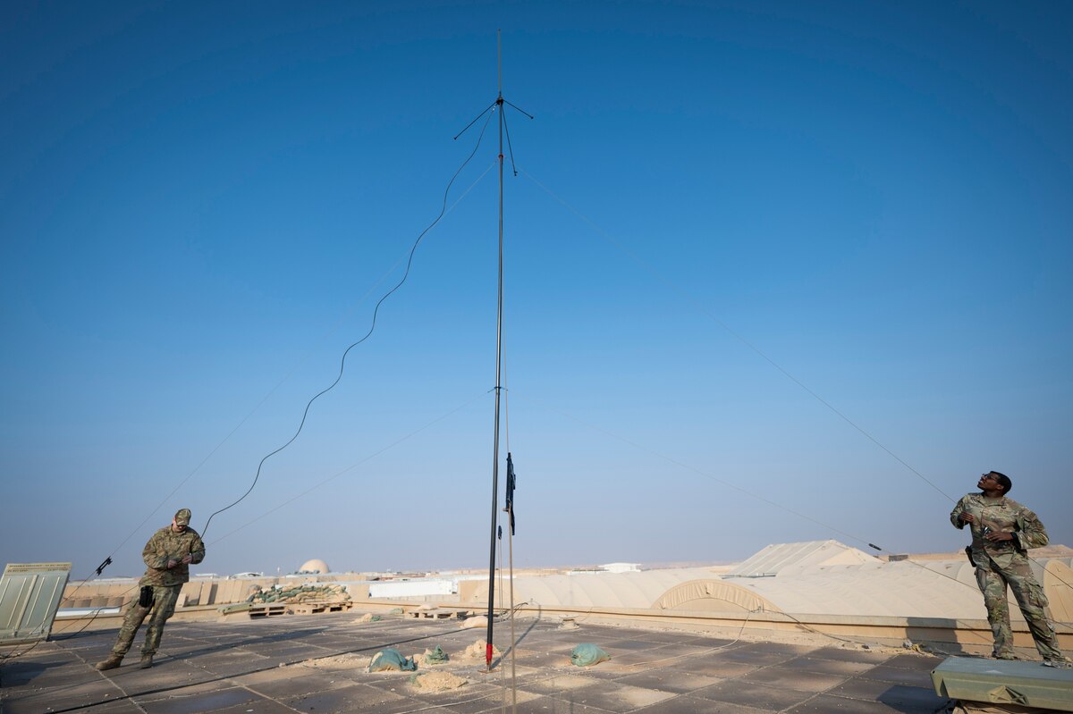 From left, U.S. Air Force Staff Sgt. Daniel Meeks, 443rd Air Expeditionary Squadron client systems technician, and Senior Airman Byron McNeill Jr., 443rd AES supply technician and security forces fireteam lead, inspect a communication antenna at Al Asad Air Base, Iraq, Dec. 11, 2022. McNeill and Meeks have installed three antennas on the installation, boosting the strength of radio signals for the Defenders on the installation. (U.S. Air Force photo by Staff Sgt. Dalton Williams)