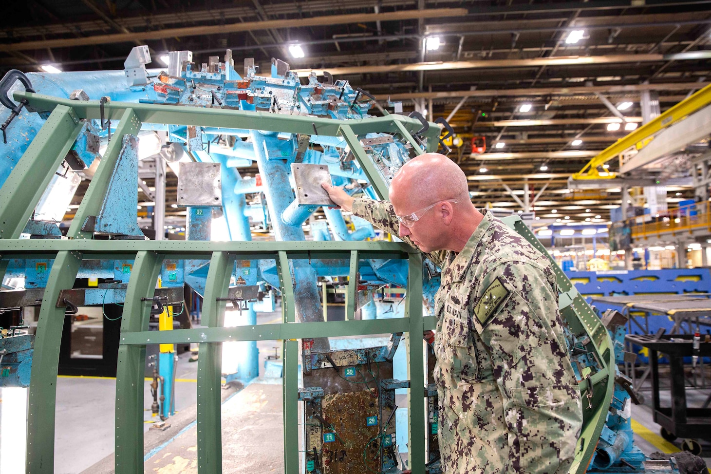 Rear Admiral Luke Frost, Director, Reserve Warfare, Office of the Chief of Navy Reserve, inspects the airframe of a C-130J Hercules during his visit to the historic United States Air Force Plant 6 in Marietta, Georgia, the production facility for the latest generation of the C-130 Hercules.; Lockheed Martin Photography by David L. Key. November 8, 2022