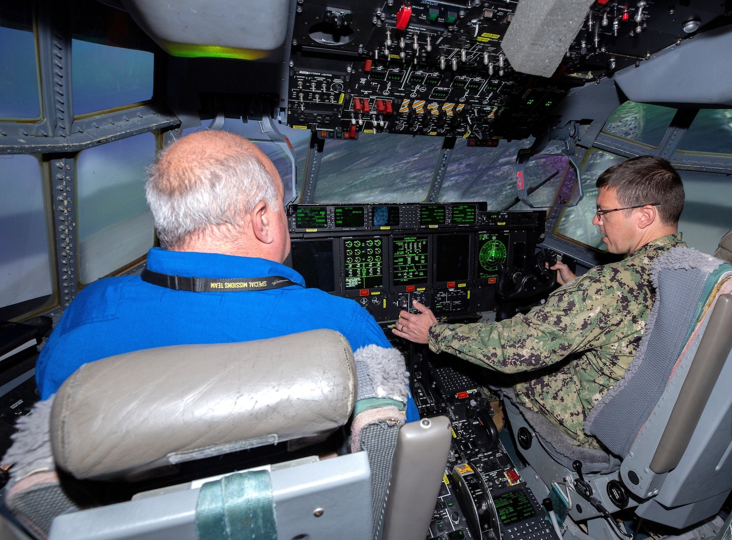 Captain Damon Hildebrand, Branch Head, Reserve Enabling Requirements, Office of the Chief of Navy Reserve (right) is seated at the flight controls of a C-130J Hercules simulator during his visit to the historic United States Air Force Plant 6 in Marietta, Georgia, the production facility for the latest generation of the C-130 Hercules. Lockheed Martin Photography by David L. Key. November 8, 2022