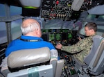 Captain Damon Hildebrand, Branch Head, Reserve Enabling Requirements, Office of the Chief of Navy Reserve (right) is seated at the flight controls of a C-130J Hercules simulator during his visit to the historic United States Air Force Plant 6 in Marietta, Georgia, the production facility for the latest generation of the C-130 Hercules. Lockheed Martin Photography by David L. Key. November 8, 2022