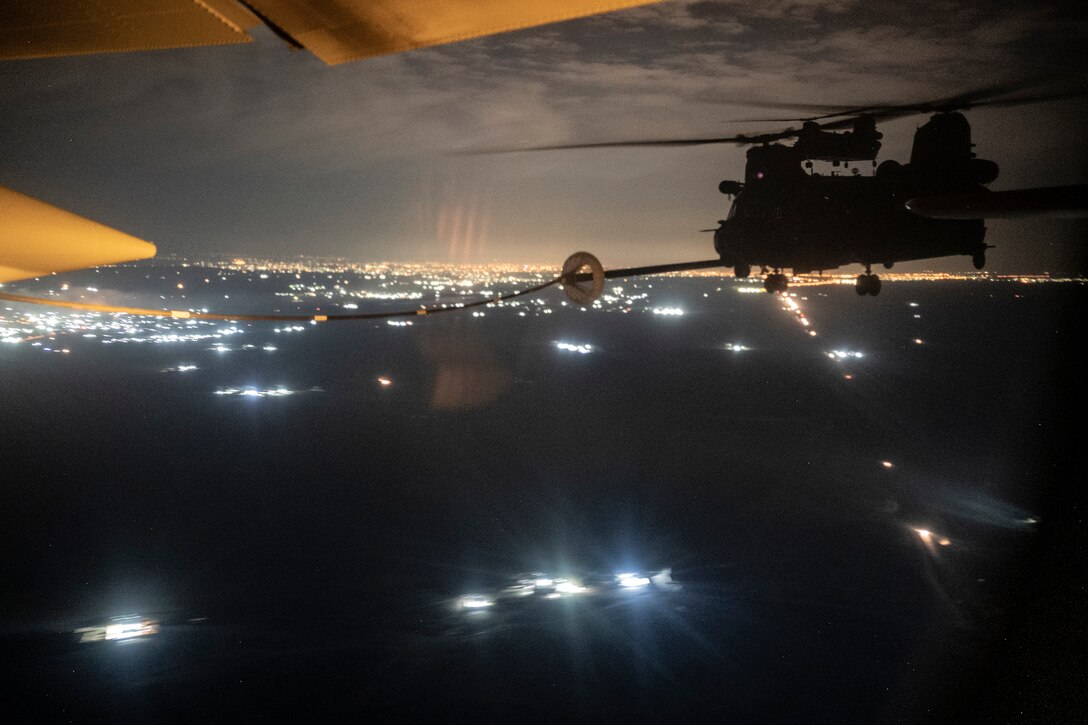 Military aircraft carry out a refueling mission while in flight.